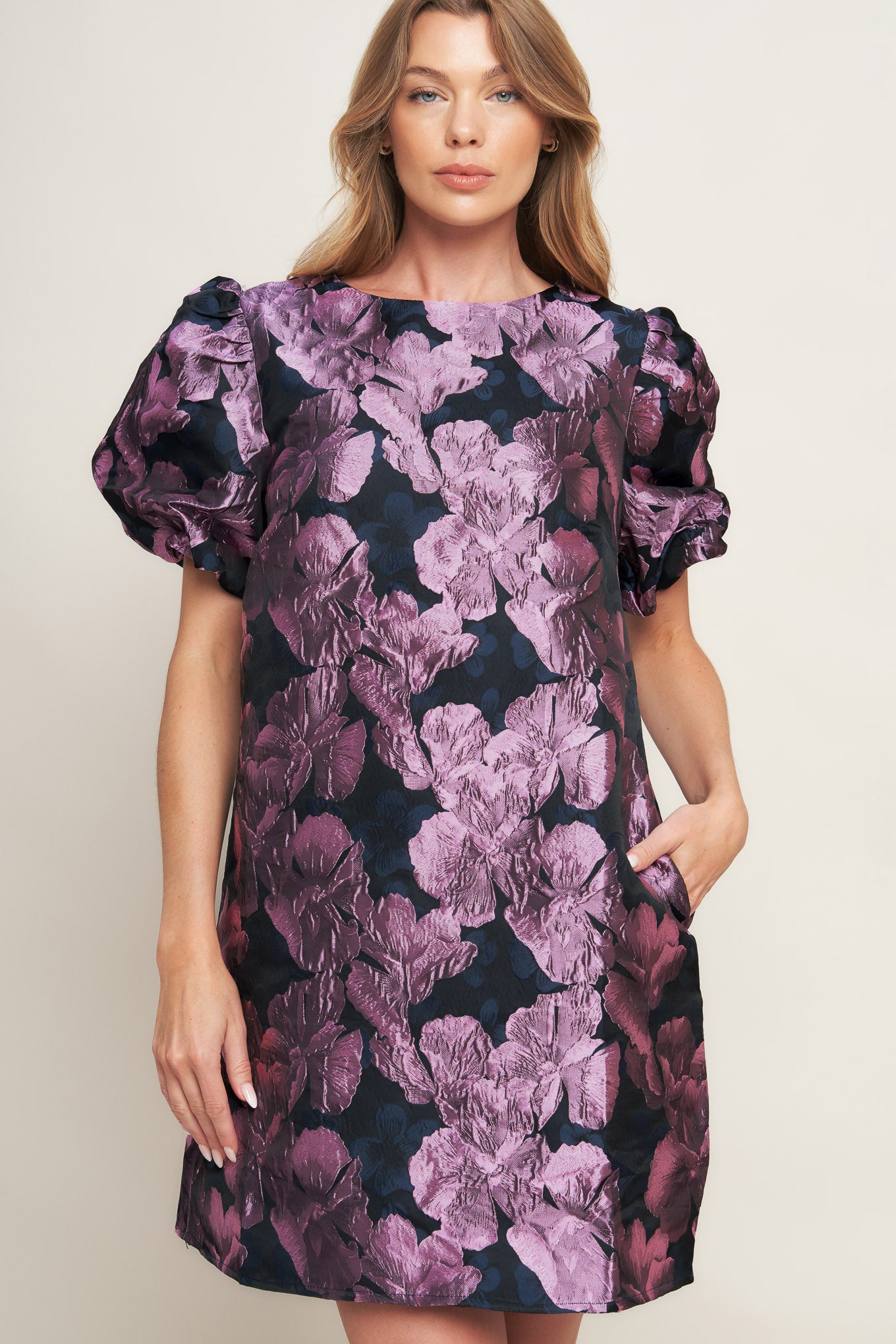 A textured woven mini dress featuring round neckline, short puff sleeve and back neck button closure
