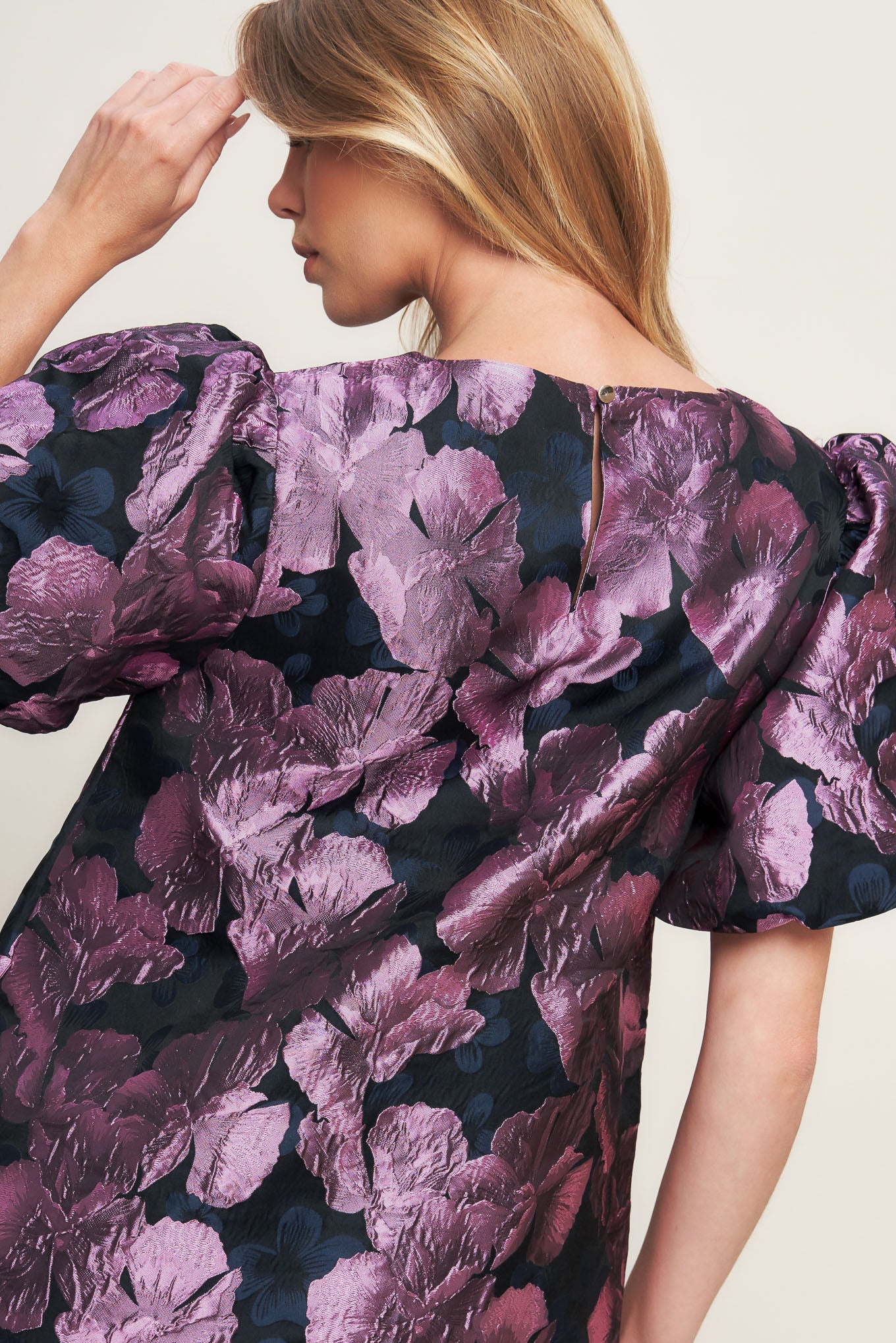 A textured woven mini dress featuring round neckline, short puff sleeve and back neck button closure