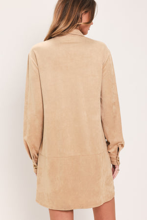 Woman wearing a long sleeve beige suede mini dress with buttons along the front, collar, and self tie matching belt | Flying Tomato