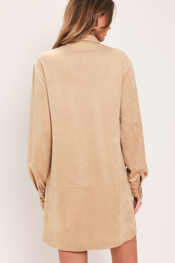 Woman wearing a long sleeve beige suede mini dress with buttons along the front, collar, and self tie matching belt | Flying Tomato