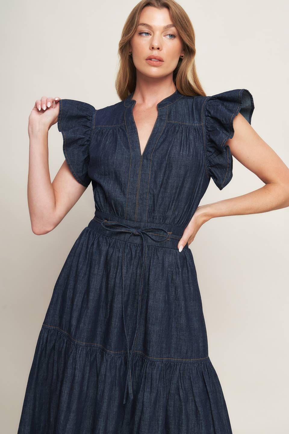 A lightweight denim midi dress featuring V neckline, short ruffle sleeve, skinny self tie, tiered skirt and smocked back waistband