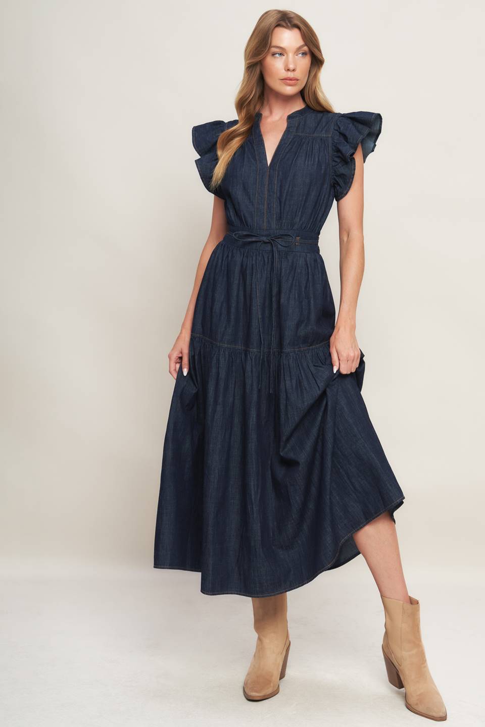 A lightweight denim midi dress featuring V neckline, short ruffle sleeve, skinny self tie, tiered skirt and smocked back waistband