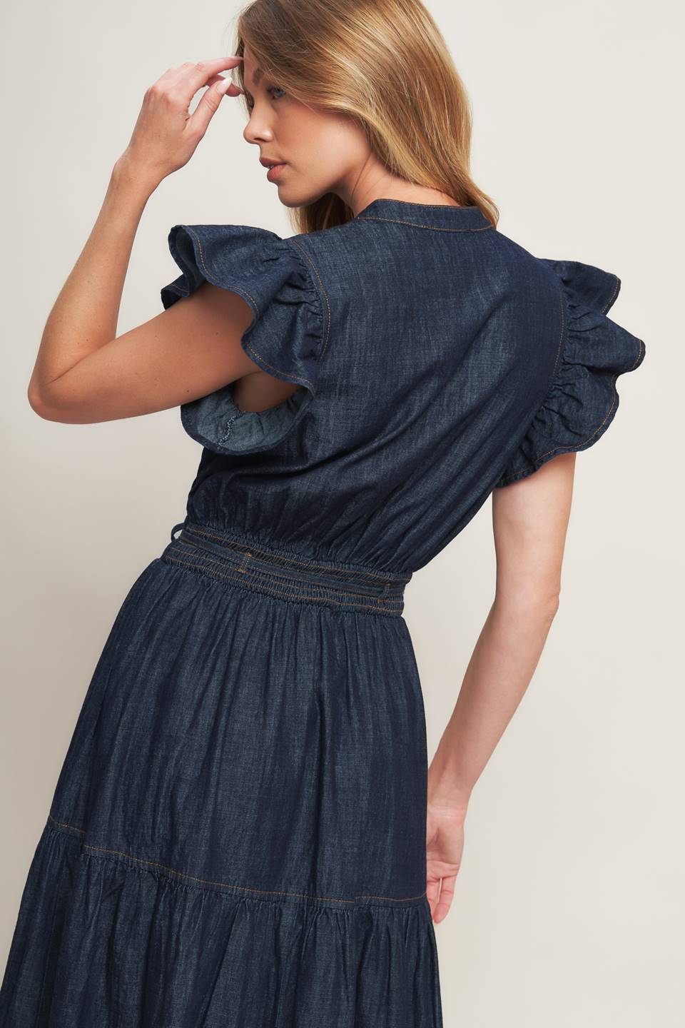 A lightweight denim midi dress featuring V neckline, short ruffle sleeve, skinny self tie, tiered skirt and smocked back waistband