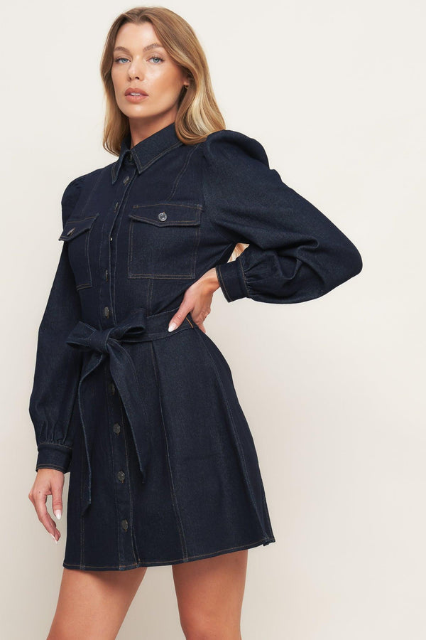 A denim mini dress featuring collar, long sleeve, front pocket, button down closure and self sash tie