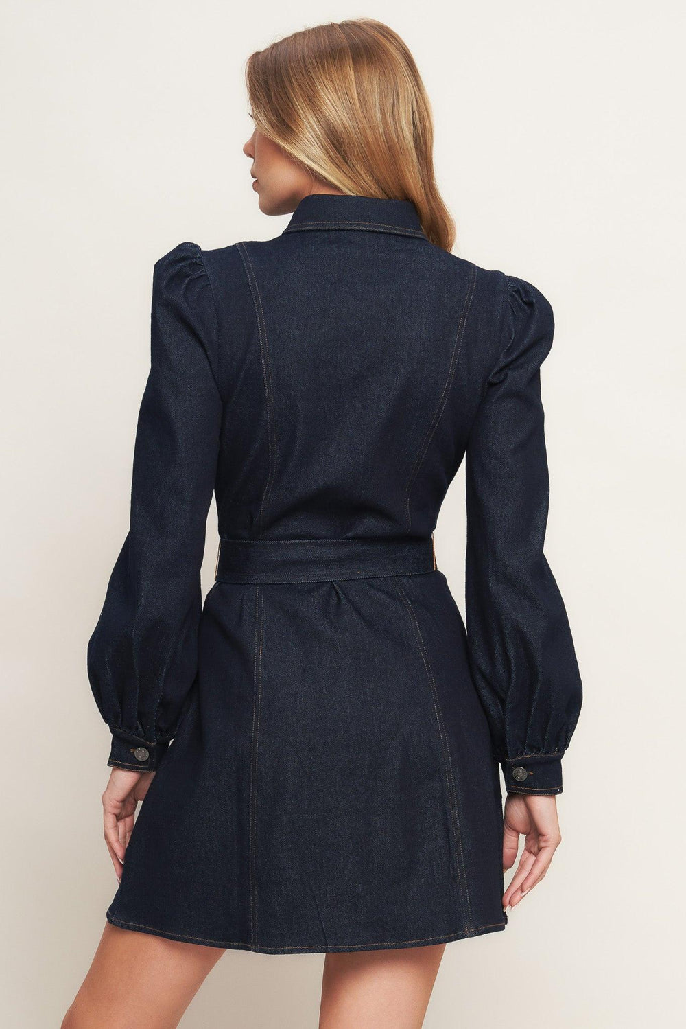 A denim mini dress featuring collar, long sleeve, front pocket, button down closure and self sash tie