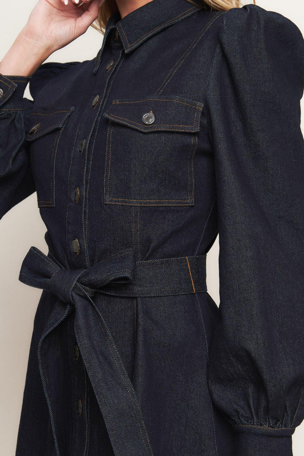 A denim mini dress featuring collar, long sleeve, front pocket, button down closure and self sash tie