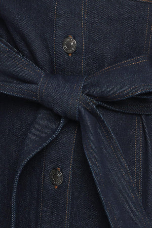 A denim mini dress featuring collar, long sleeve, front pocket, button down closure and self sash tie