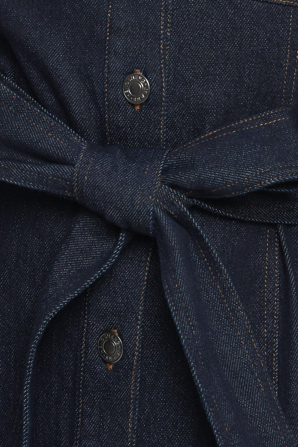 A denim mini dress featuring collar, long sleeve, front pocket, button down closure and self sash tie