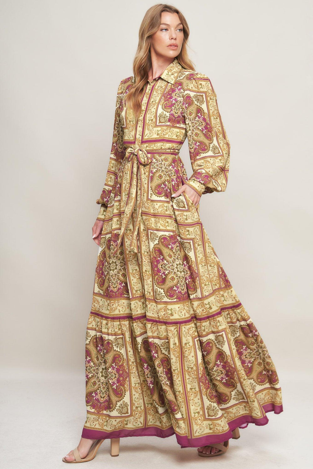 A printed woven maxi dress featuring collar, long sleeve with cuff, front button down, self sash tie and ruffled hemline