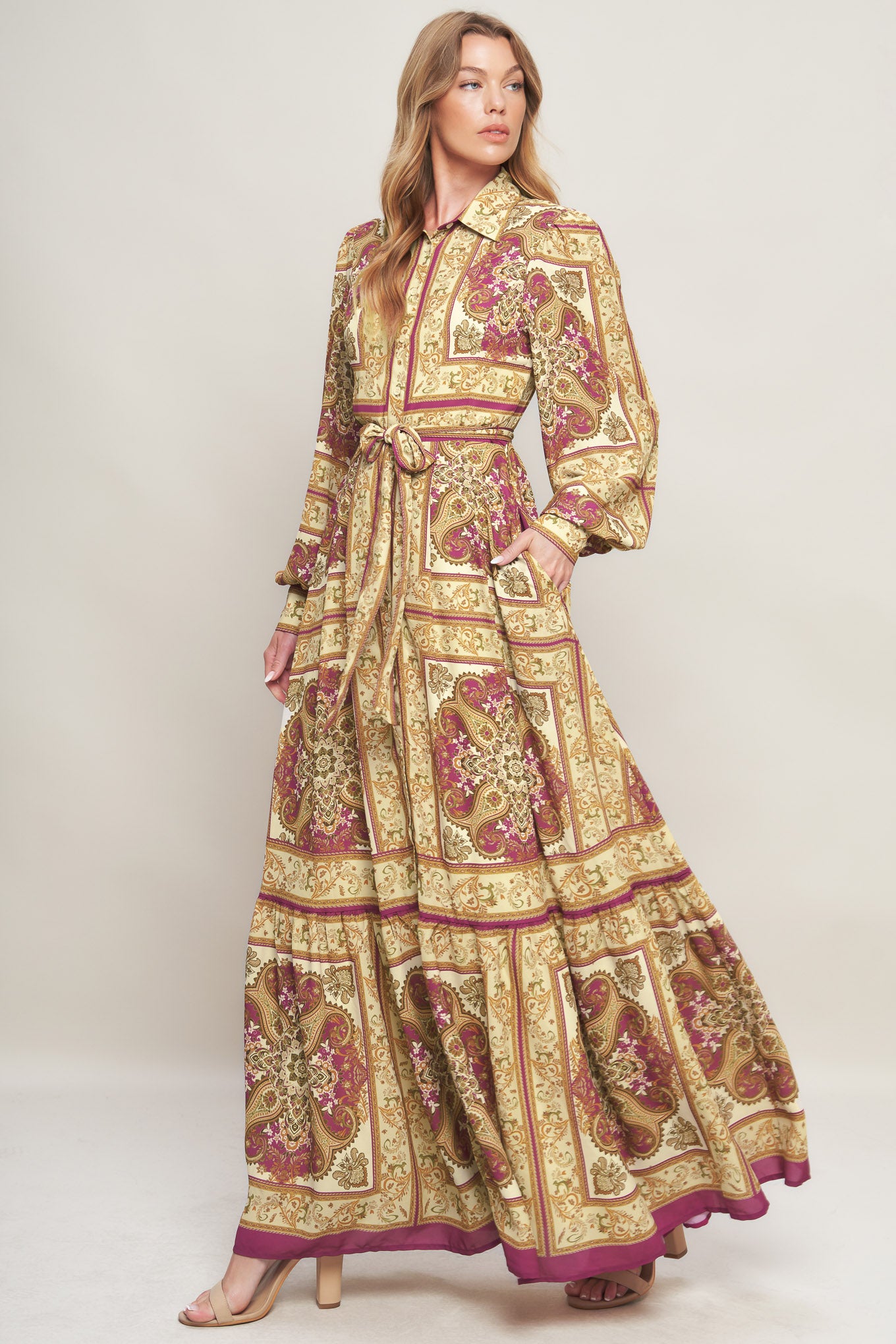 A printed woven maxi dress featuring collar, long sleeve with cuff, front button down, self sash tie and ruffled hemline