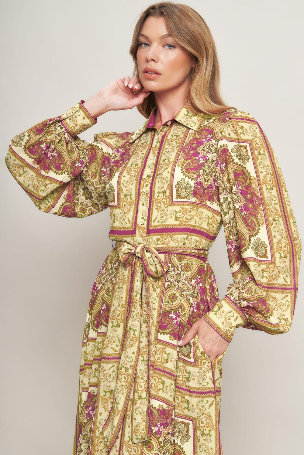 A printed woven maxi dress featuring collar, long sleeve with cuff, front button down, self sash tie and ruffled hemline