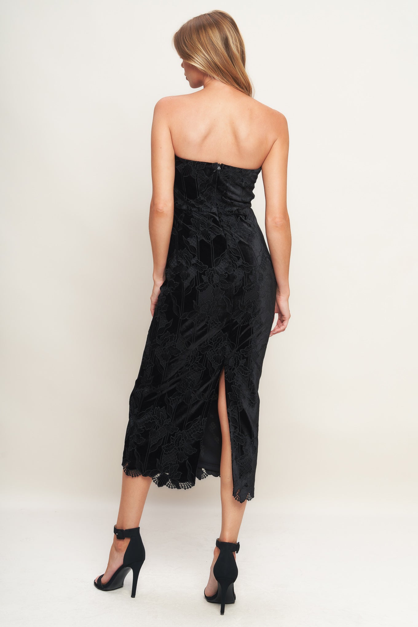 A woven velvet lace midi dress featuring strapless neckline and back zipper closure with slit