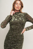 A burnout velvet midi dress featuring tubular neckline, long sleeve, side shirring and back zipper closure
