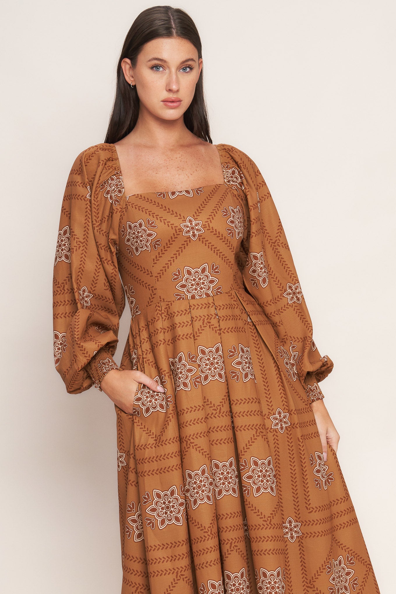 A printed woven midi dress featuring square neckline, long sleeve with smocked cuff, full skirt and smocked back bodice