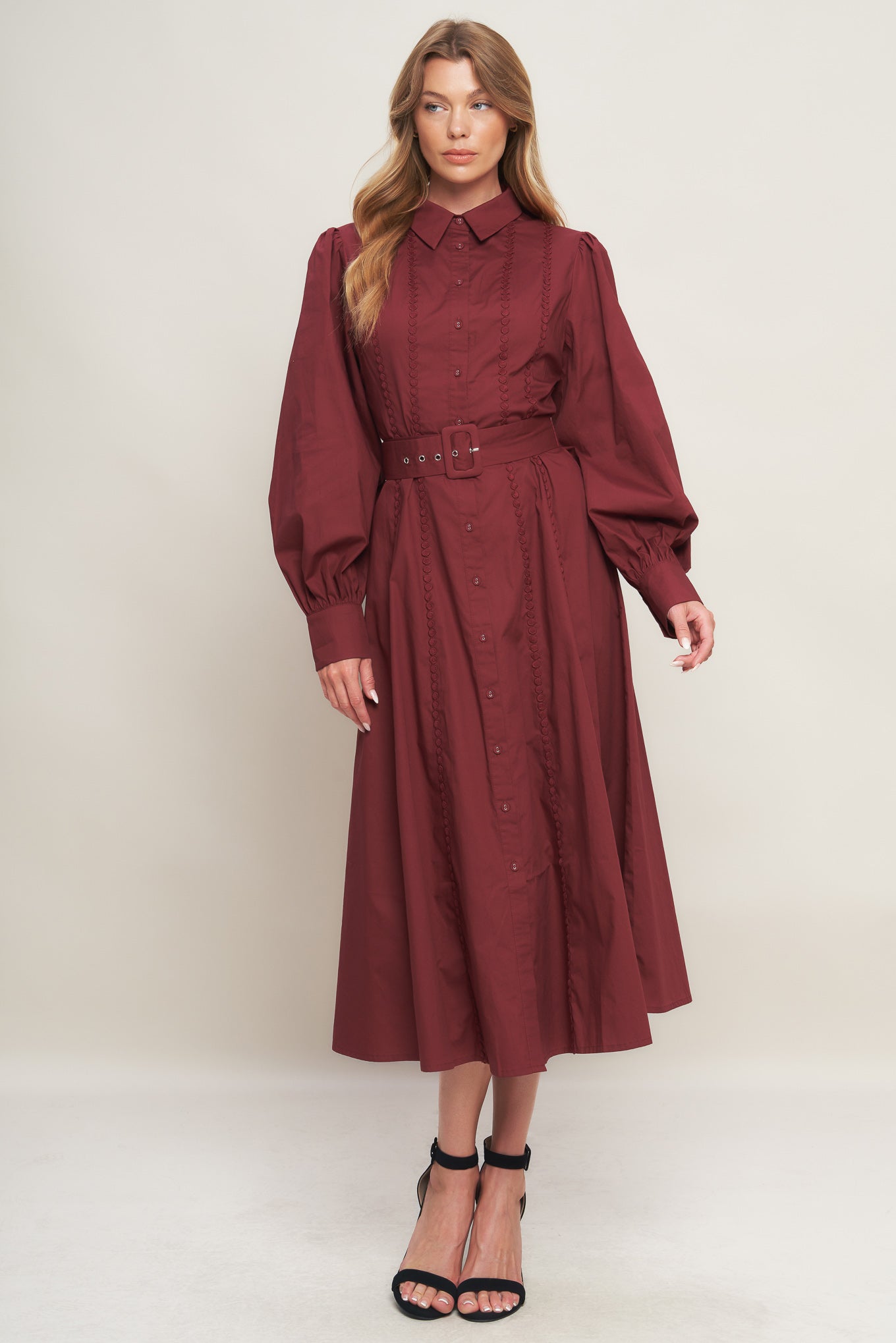 A solid woven midi dress featuring collar, button down, lace trim detail, long sleeve, self belt and full skirt