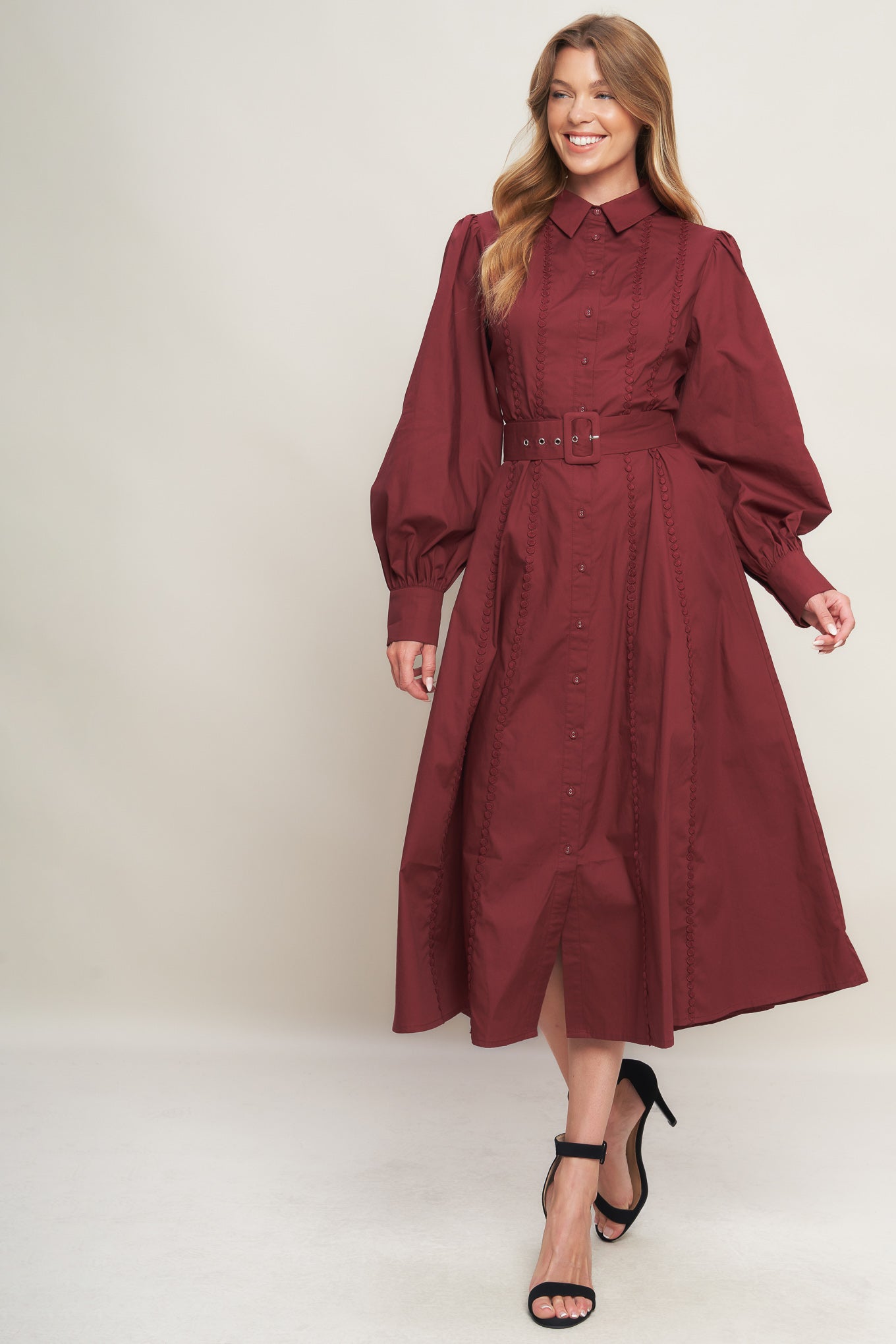 A solid woven midi dress featuring collar, button down, lace trim detail, long sleeve, self belt and full skirt