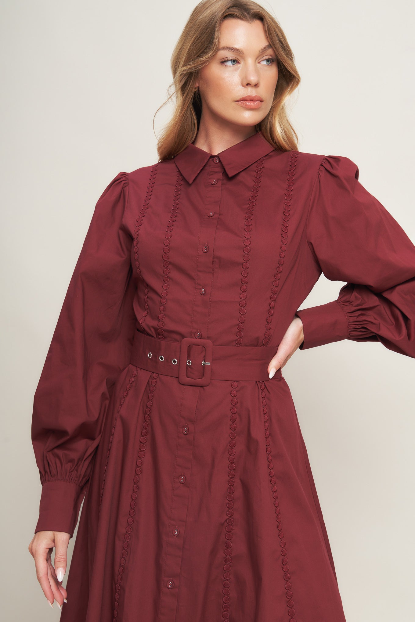 A solid woven midi dress featuring collar, button down, lace trim detail, long sleeve, self belt and full skirt