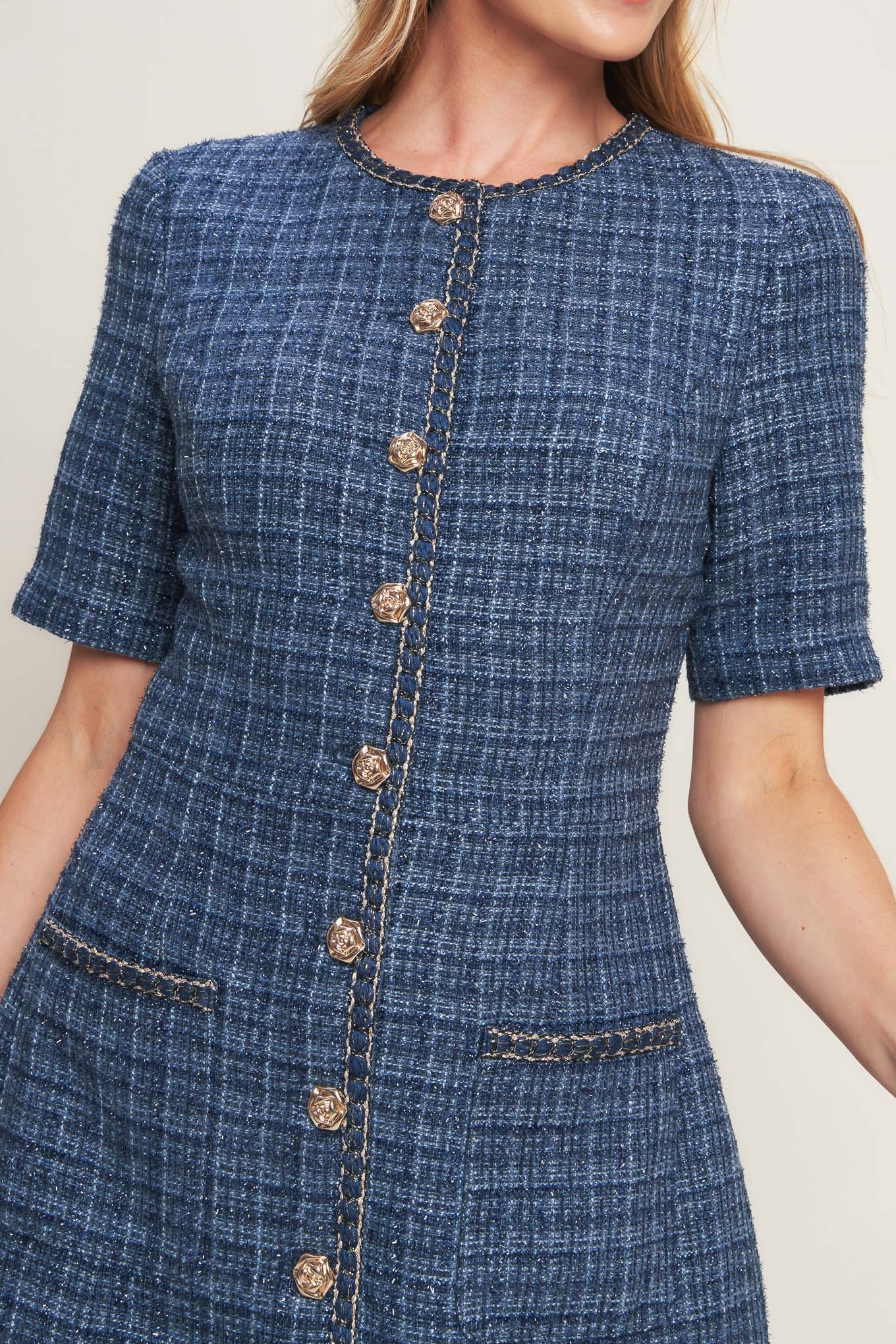 A tweed mini dress featuring round neckline, short sleeve, front button down with chain trimmed edge and pockets