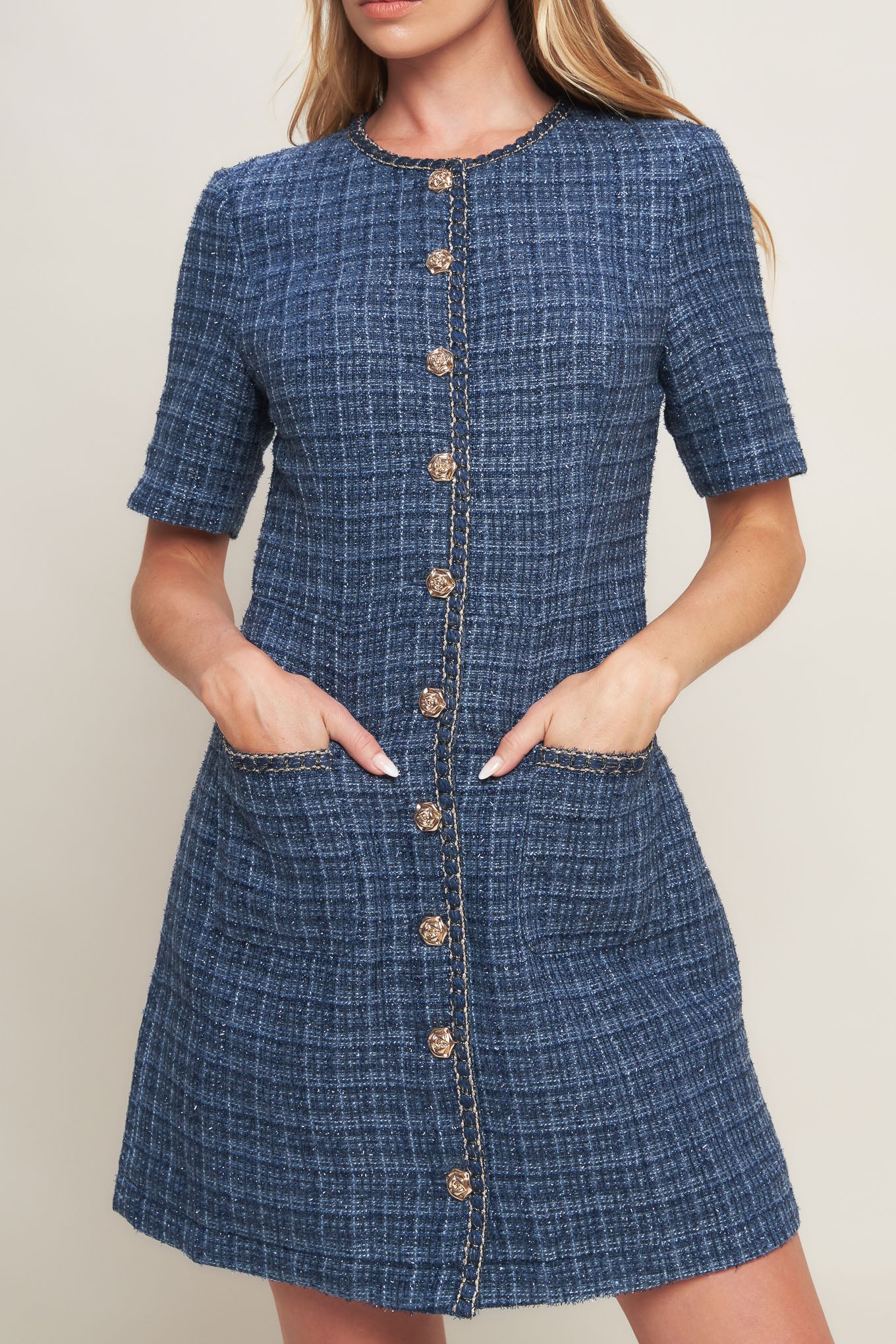 A tweed mini dress featuring round neckline, short sleeve, front button down with chain trimmed edge and pockets