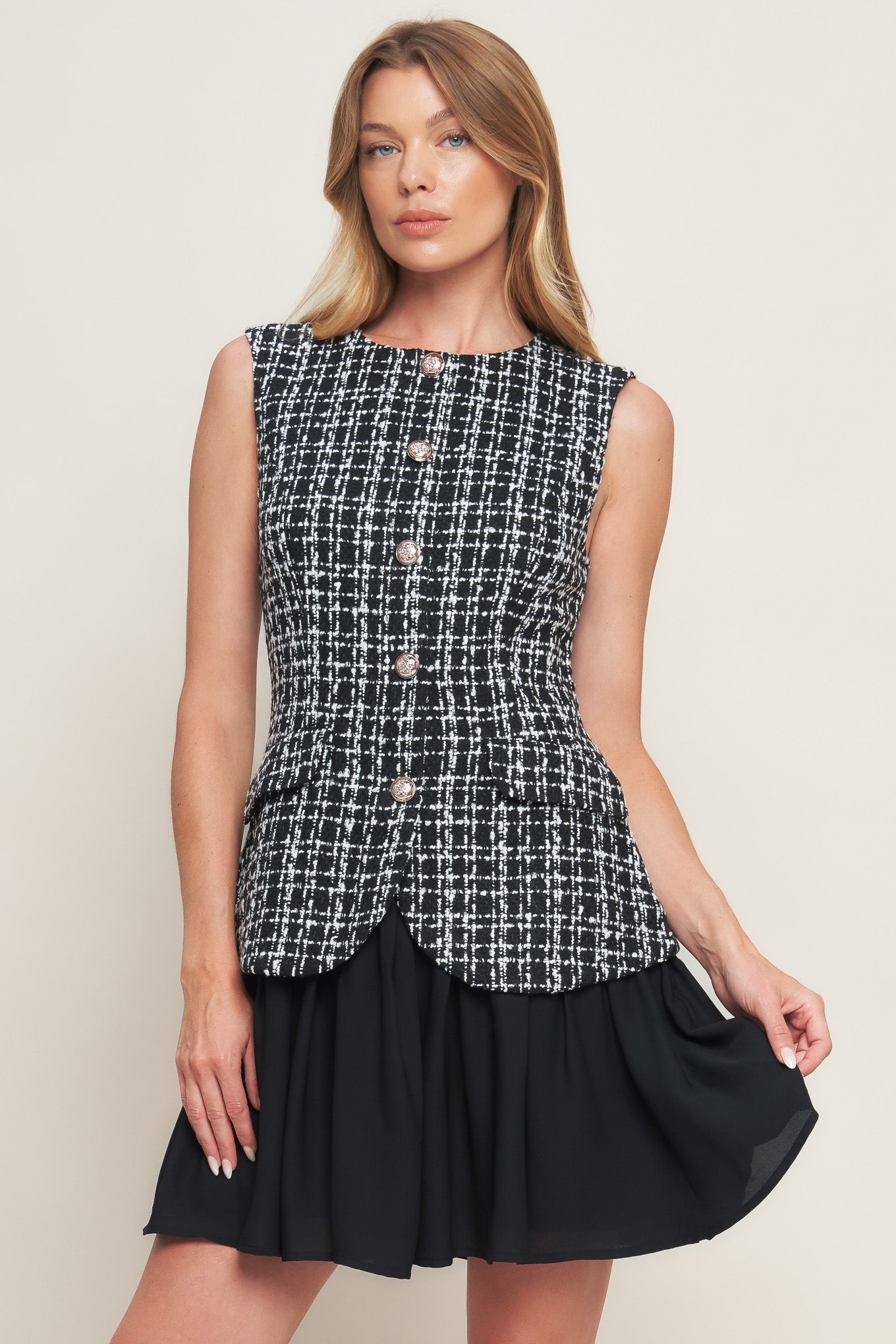A tweed and solid woven mini dress featuring round neckline, sleeveless, front button down and flowy solid skirt