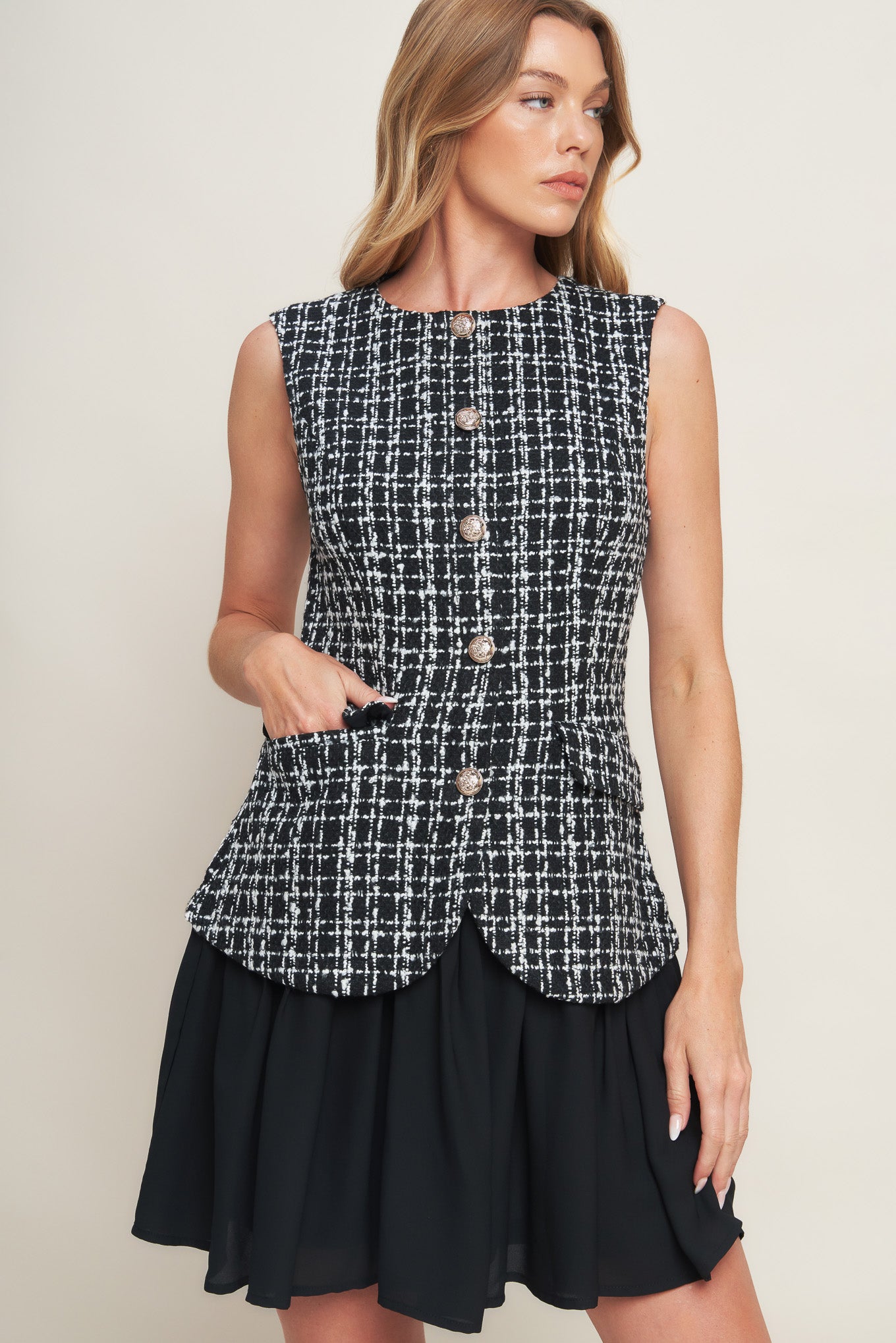 A tweed and solid woven mini dress featuring round neckline, sleeveless, front button down and flowy solid skirt