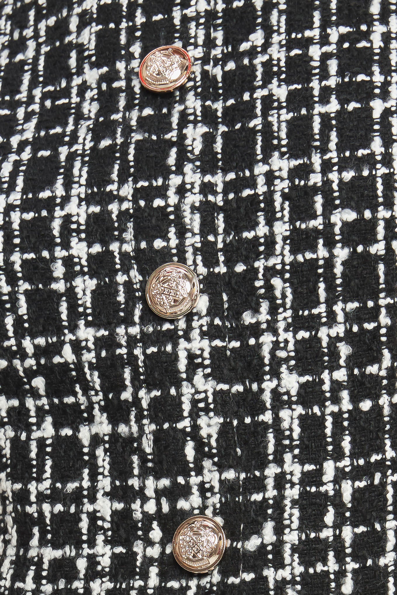 A tweed and solid woven mini dress featuring round neckline, sleeveless, front button down and flowy solid skirt