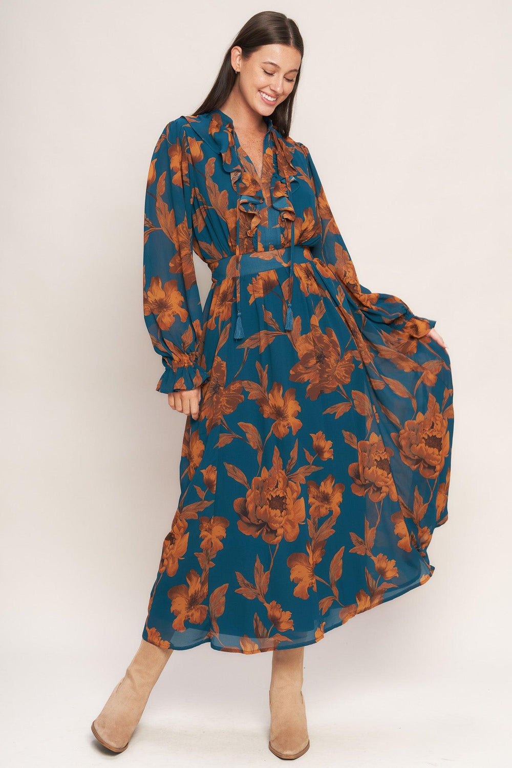 A printed woven midi dress featuring front tie/tassel with ruffles, long sleeve with ruffled cuff and elasticized waist