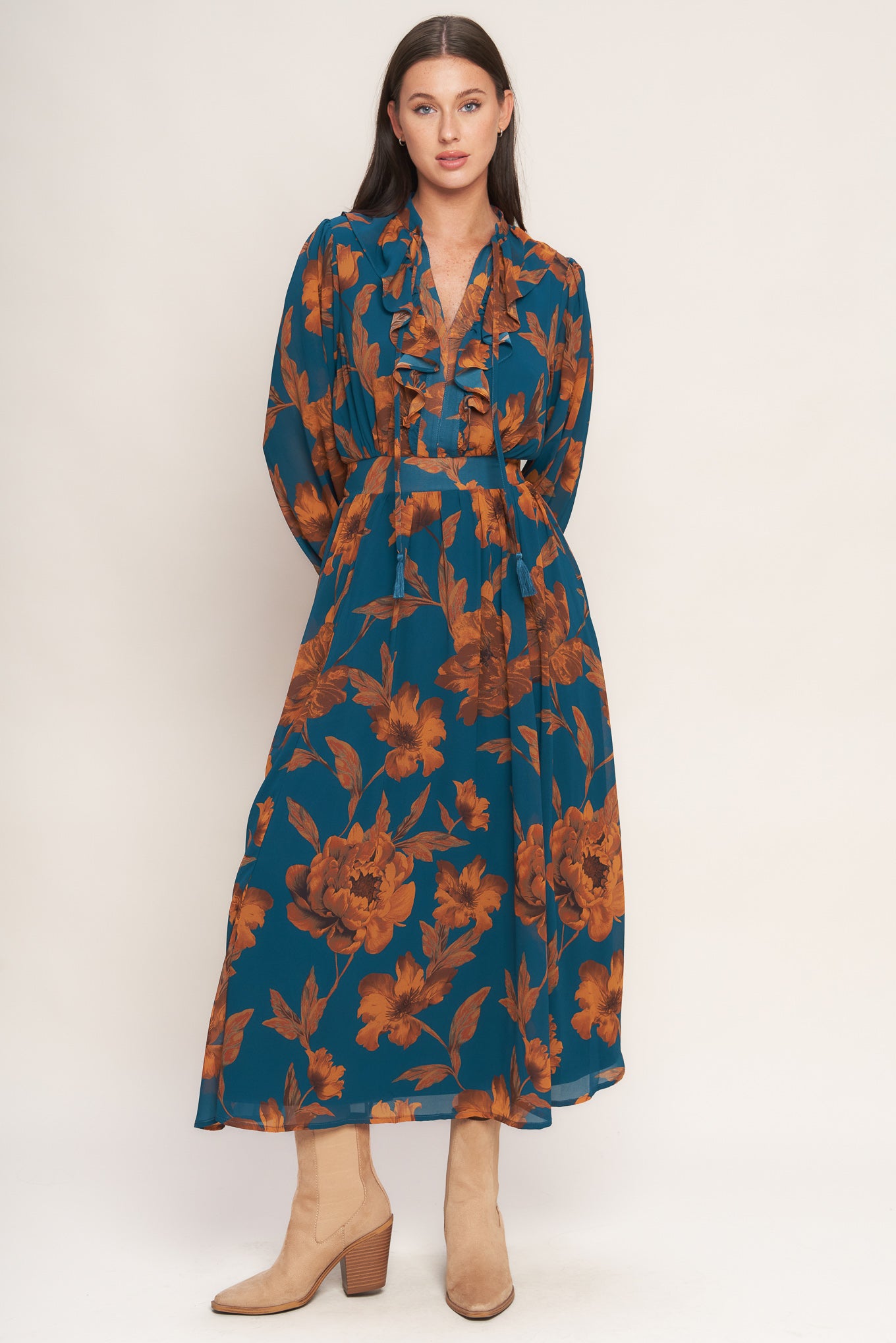 A printed woven midi dress featuring front tie/tassel with ruffles, long sleeve with ruffled cuff and elasticized waist