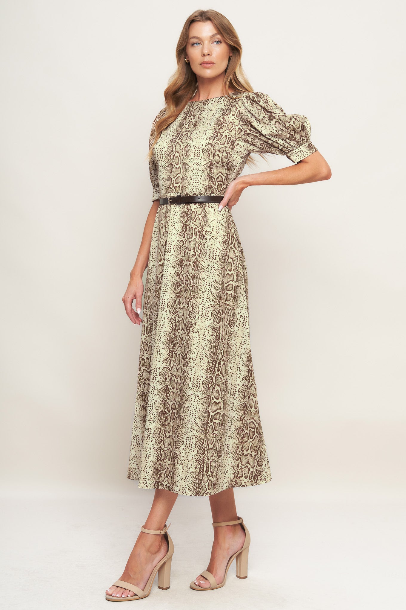 A printed woven midi dress featuring round neckline, short puff sleeve with cuff, contrasting belt, circle skirt and back zipper closure
