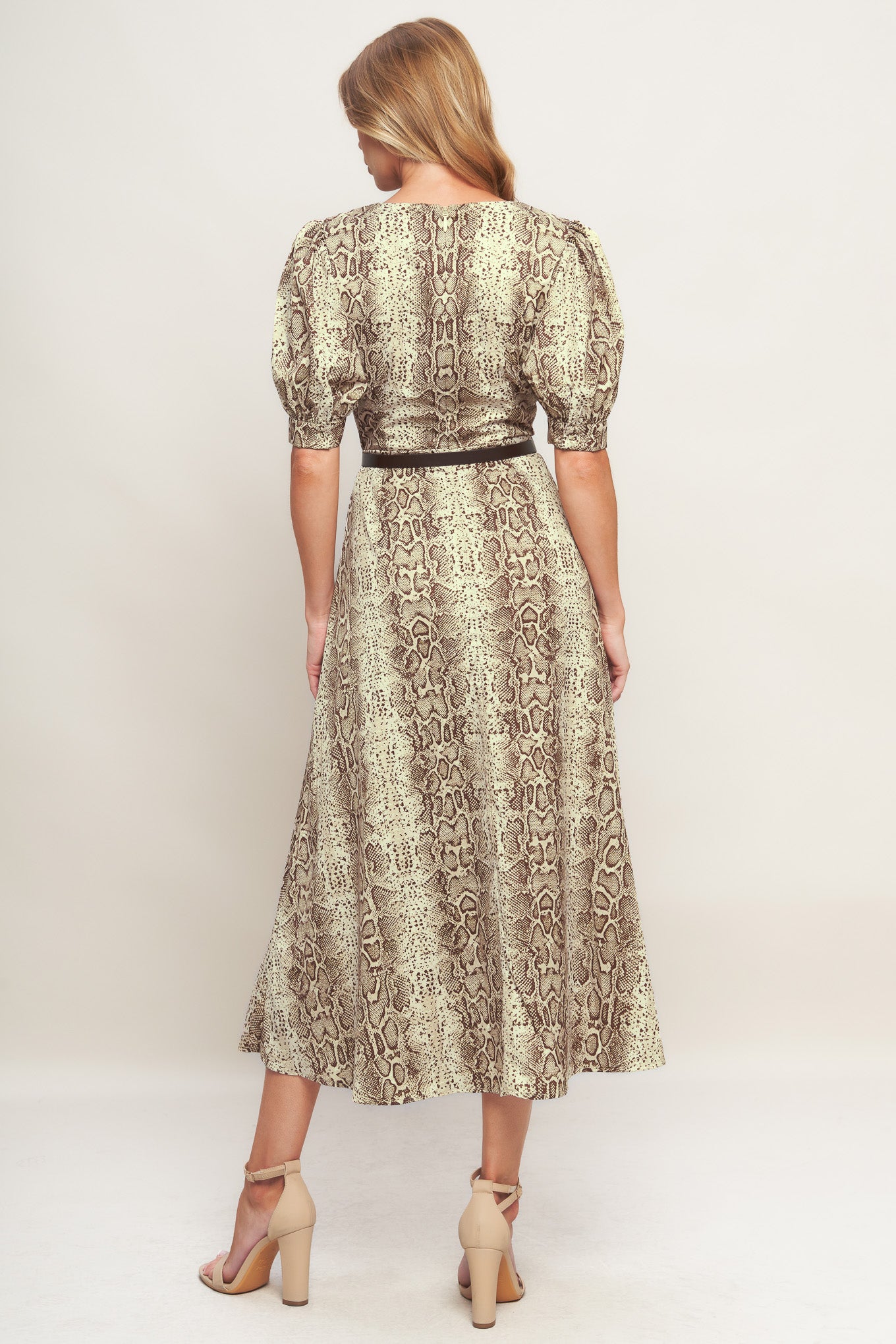 A printed woven midi dress featuring round neckline, short puff sleeve with cuff, contrasting belt, circle skirt and back zipper closure