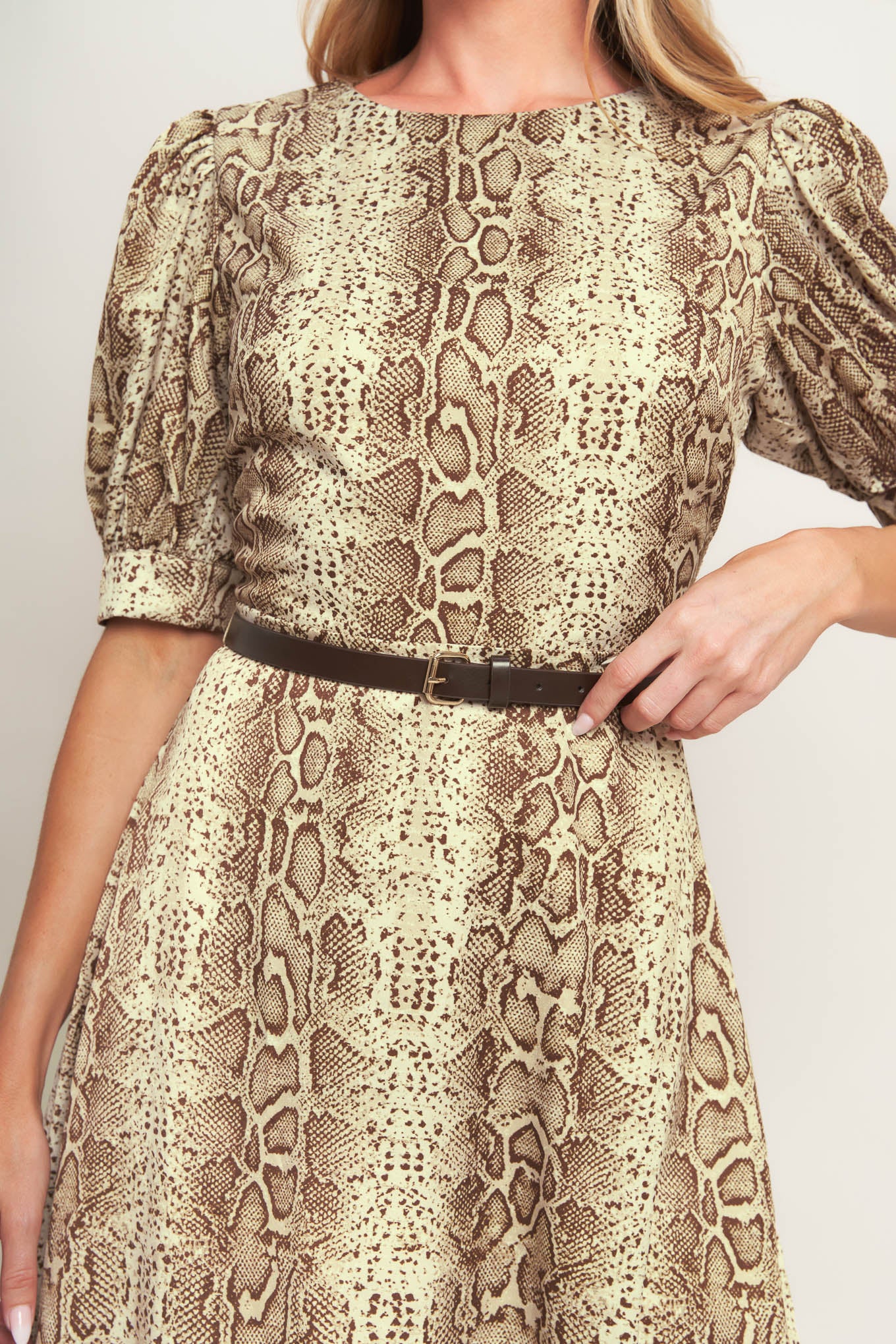A printed woven midi dress featuring round neckline, short puff sleeve with cuff, contrasting belt, circle skirt and back zipper closure