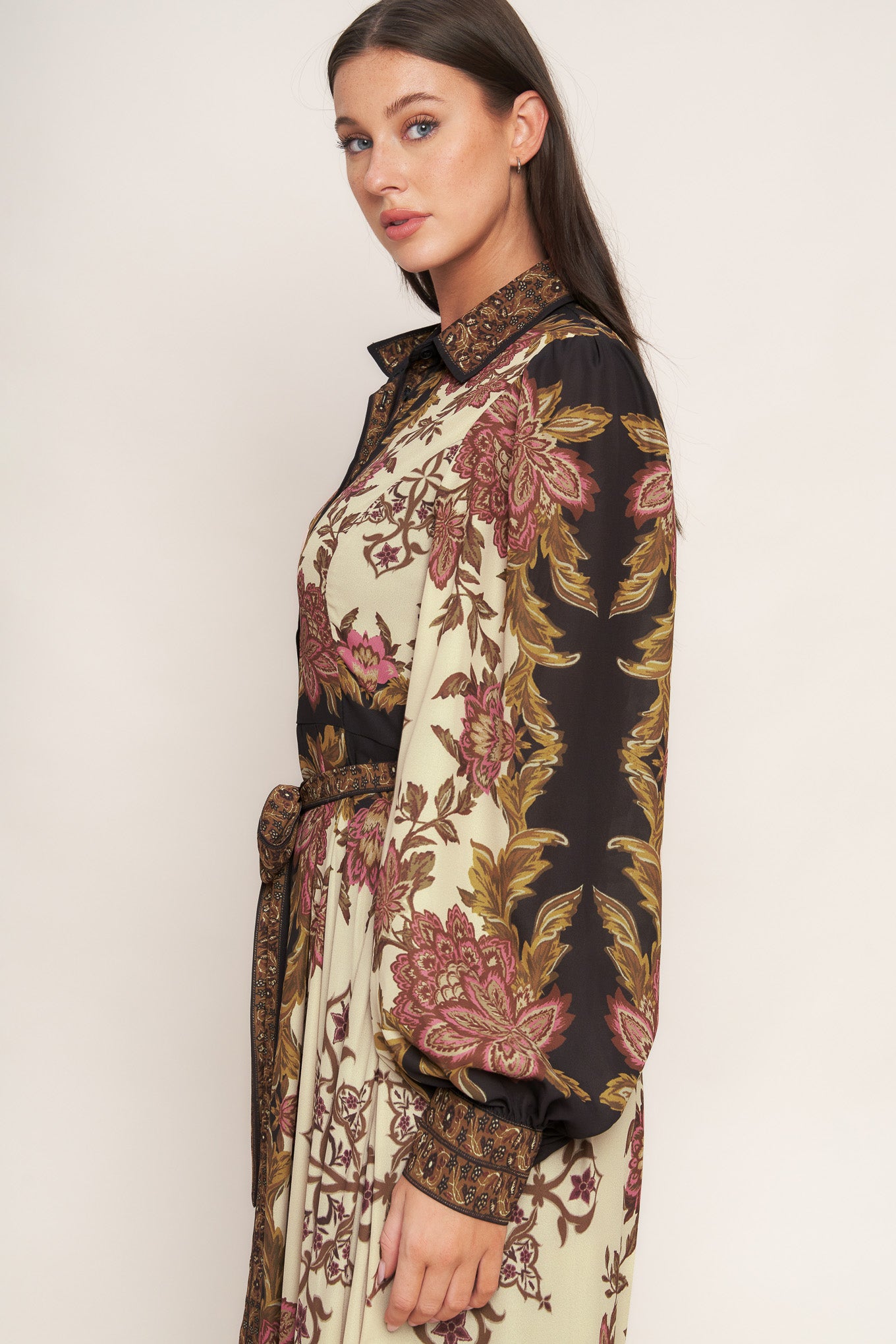 A printed woven maxi dress featuring collar, button down, long sleeve with cuff, self sash tie, and ruffled hemline
