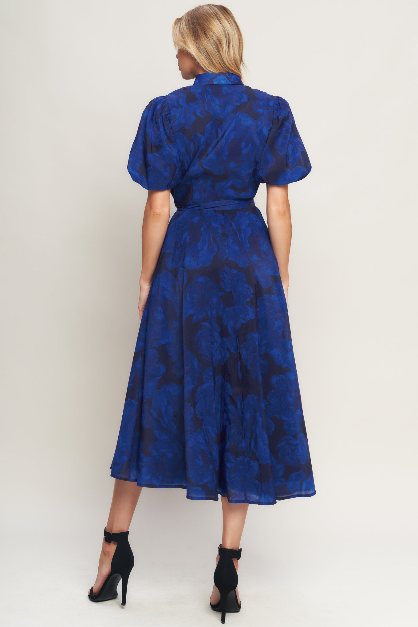 A printed woven midi dress featuring collar, front button down, short puff sleeve, self sash tie and full skirt