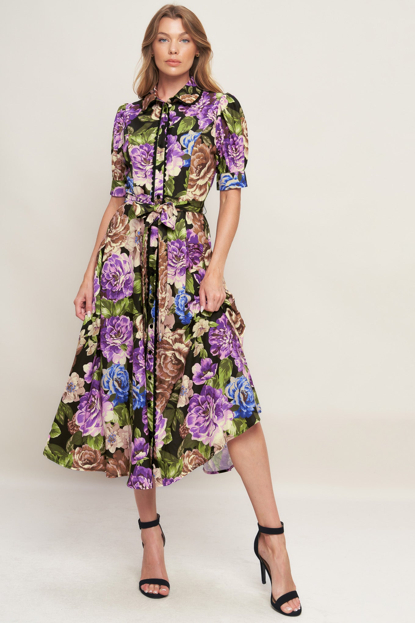 A printed woven midi dress featuring collar, short puff sleeve with cuff, button down closure and self sash tie