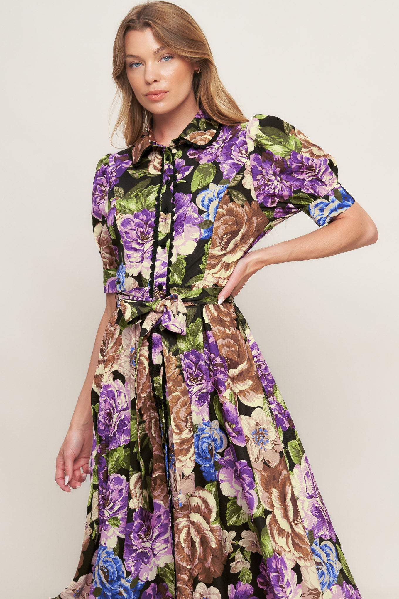 A printed woven midi dress featuring collar, short puff sleeve with cuff, button down closure and self sash tie