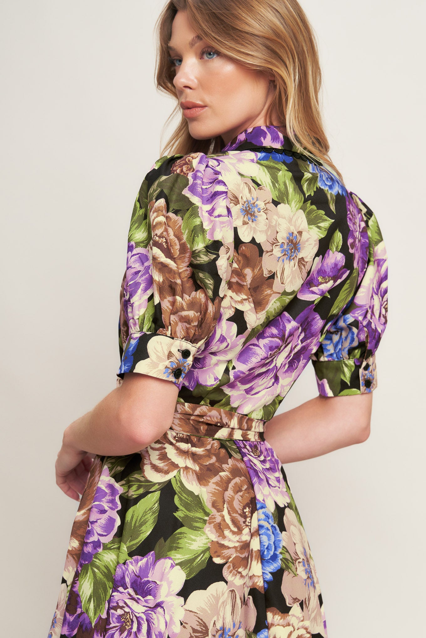 A printed woven midi dress featuring collar, short puff sleeve with cuff, button down closure and self sash tie