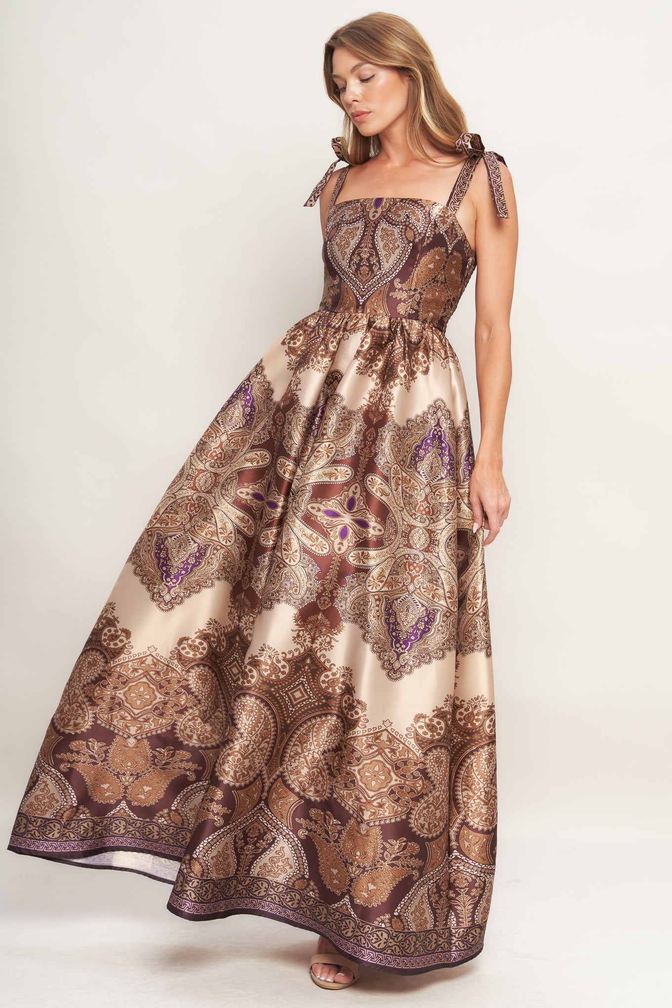 A printed woven maxi dress featuring straight neckline, shoulder tie, full skirt and smocked back bodice