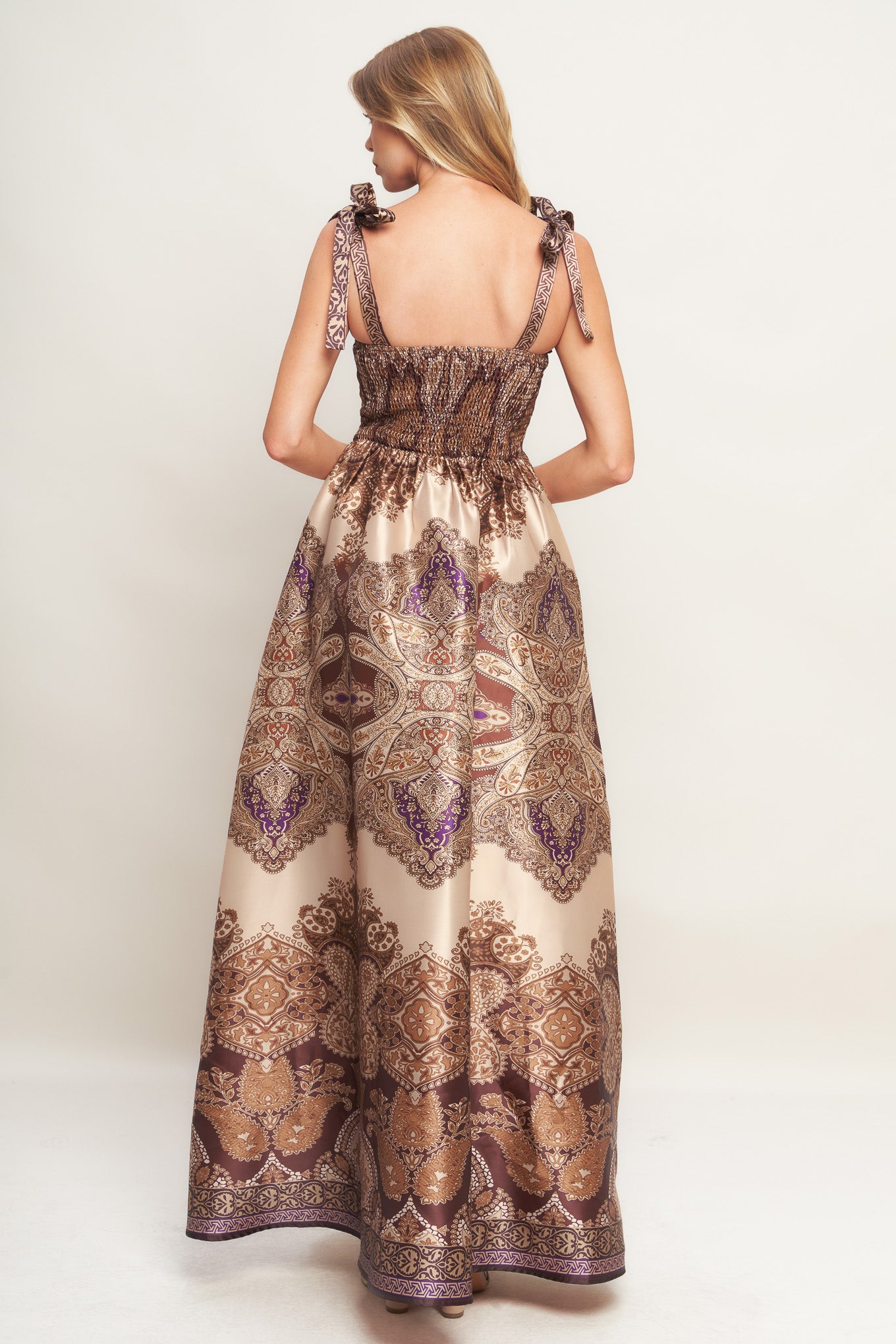 A printed woven maxi dress featuring straight neckline, shoulder tie, full skirt and smocked back bodice