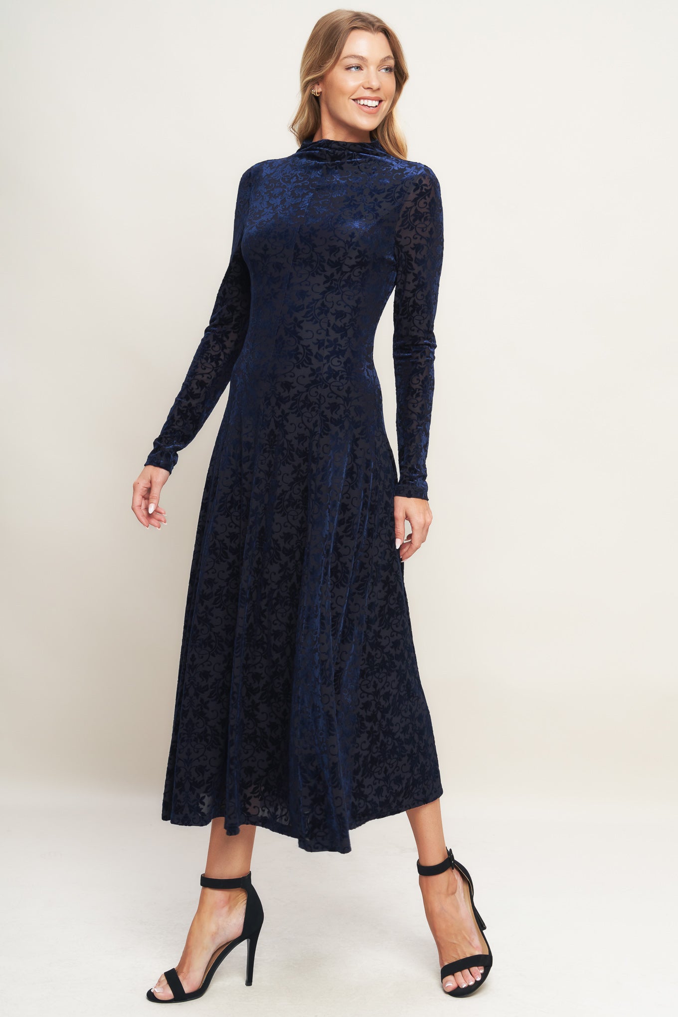 A knit burn out velvet midi dress featuring tubular neckline, long sleeve, circle skirt and back zipper closure