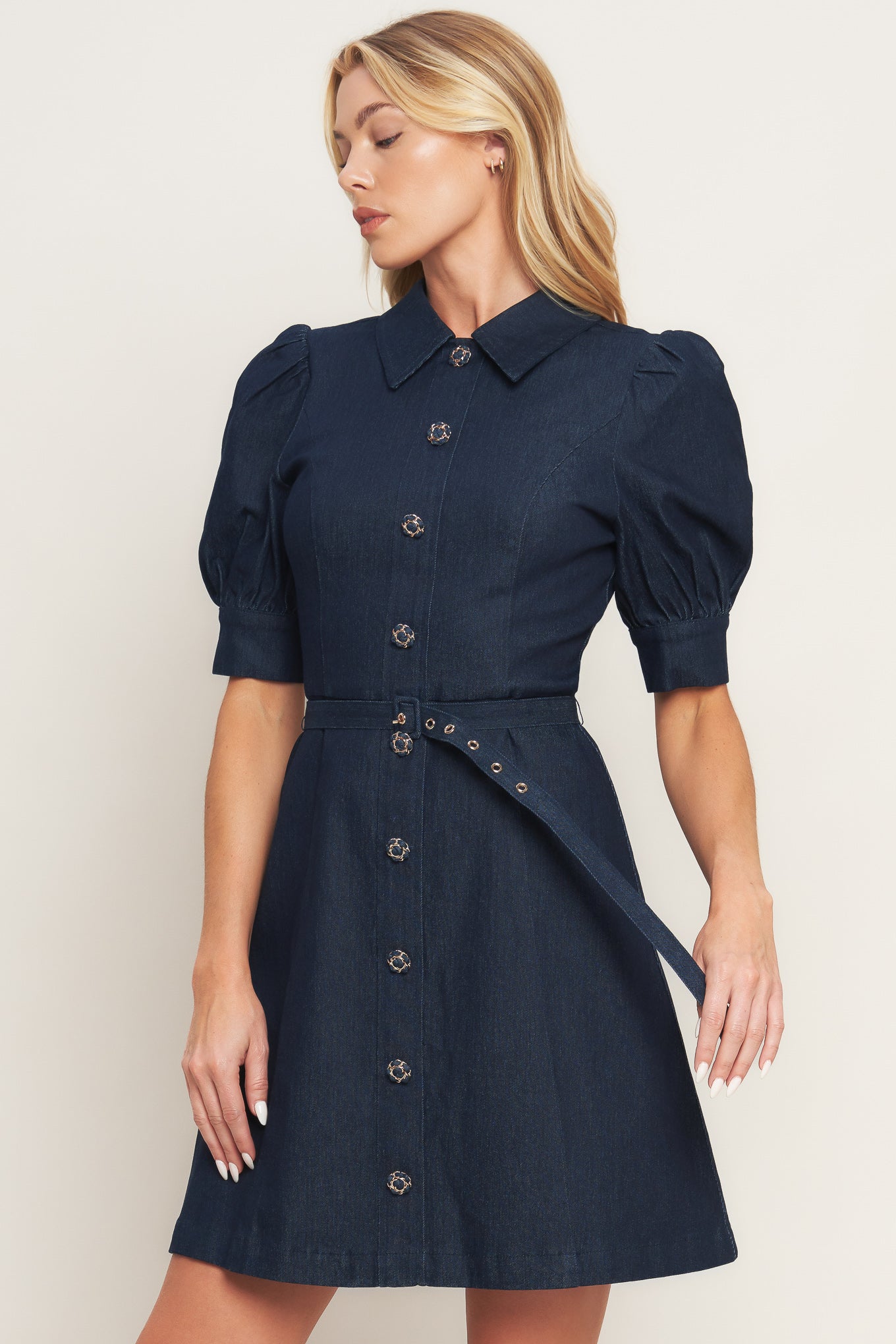 A denim mini dress featuring collar, 3/4 sleeve, front button down detail and back zipper closure