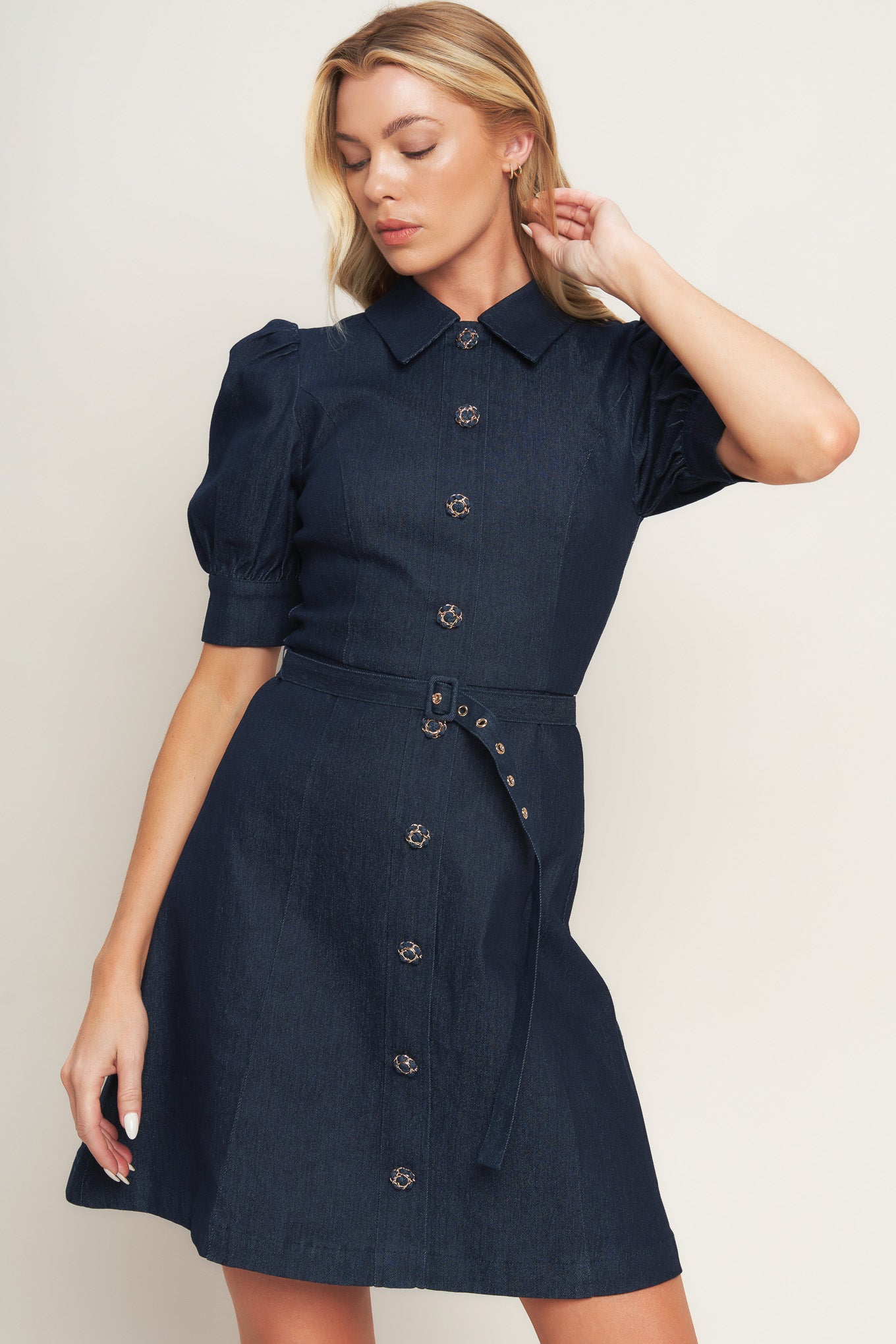 A denim mini dress featuring collar, 3/4 sleeve, front button down detail and back zipper closure