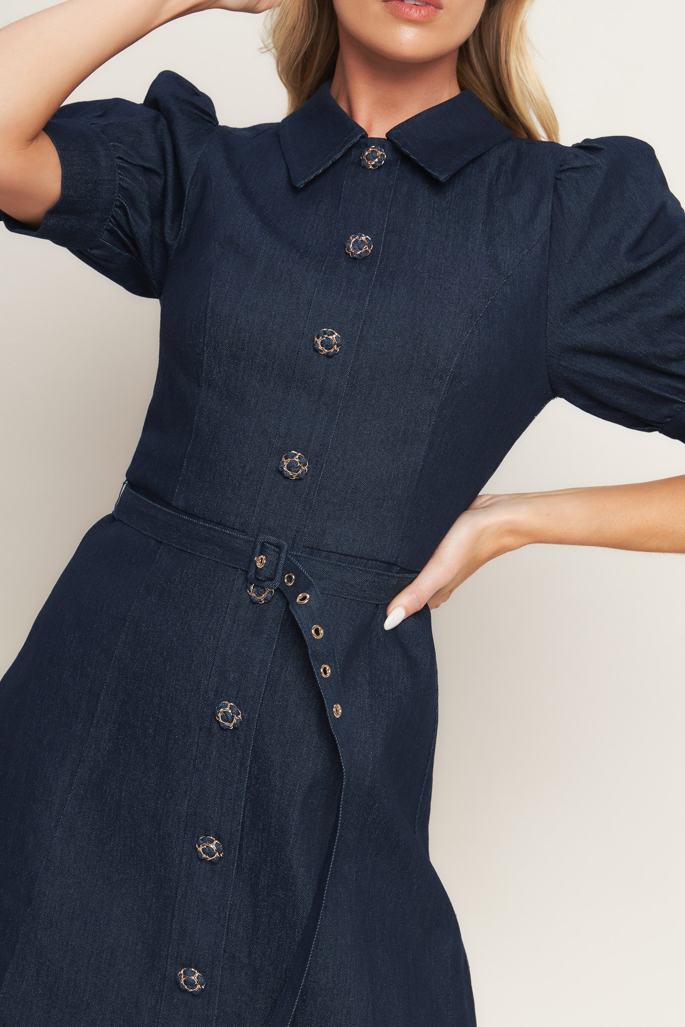 A denim mini dress featuring collar, 3/4 sleeve, front button down detail and back zipper closure