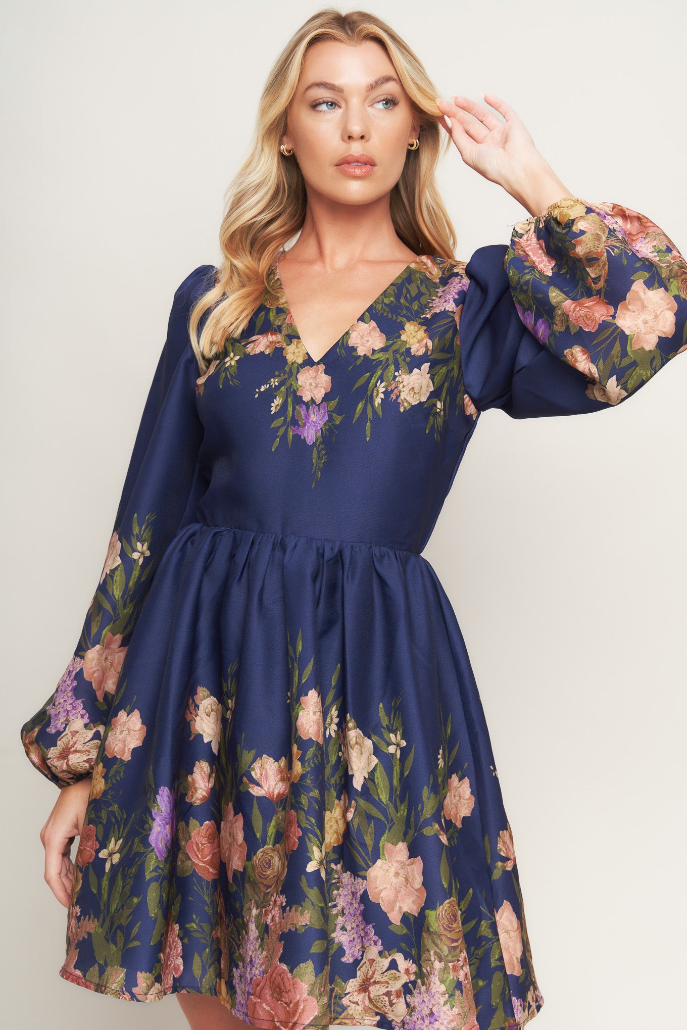 A printed woven mini dress featuring V neckline, long sleeve, full skirt and back zipper closure