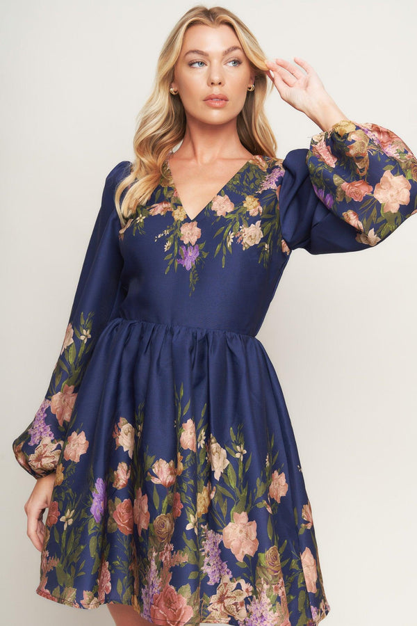 A printed woven mini dress featuring V neckline, long sleeve, full skirt and back zipper closure