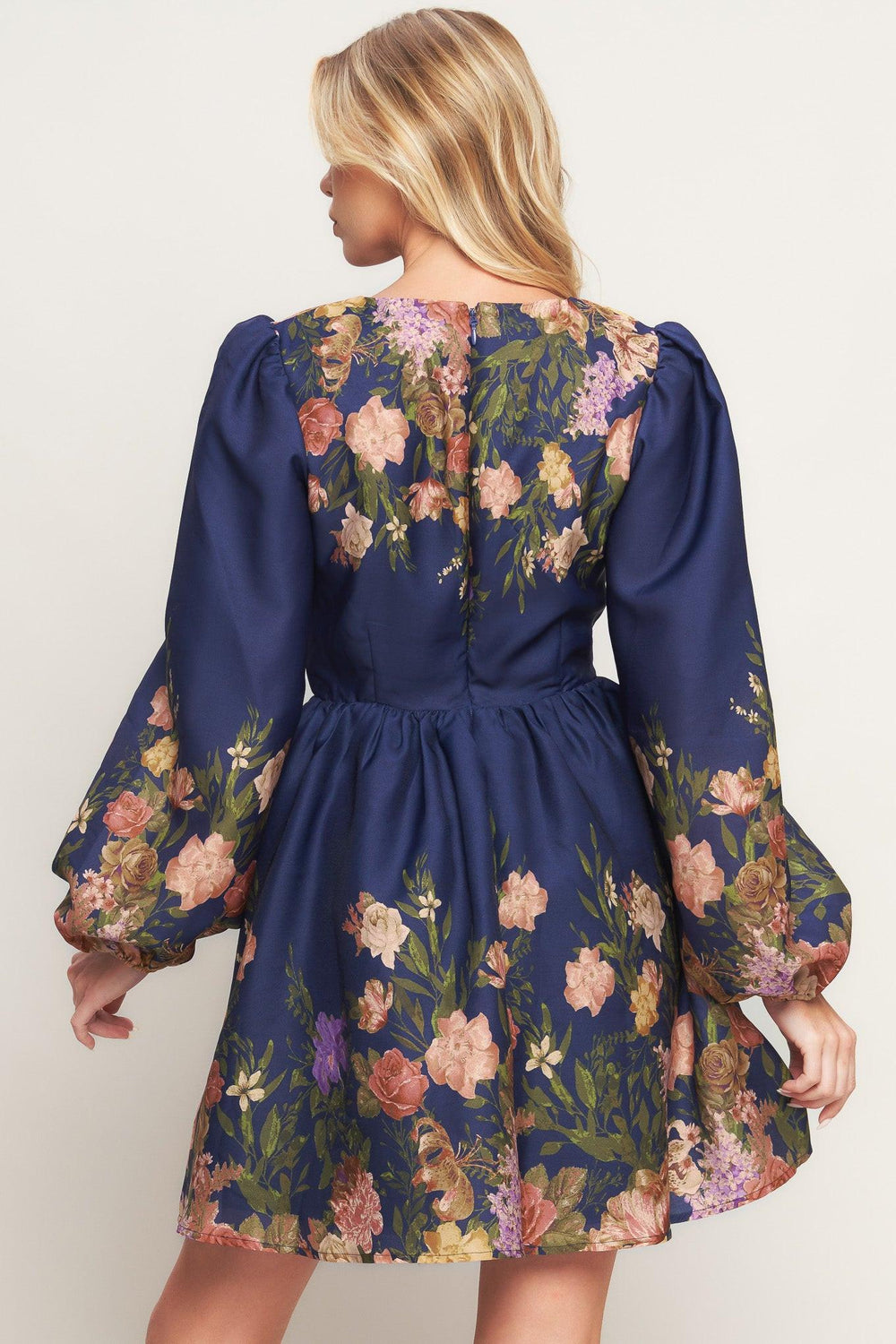 A printed woven mini dress featuring V neckline, long sleeve, full skirt and back zipper closure