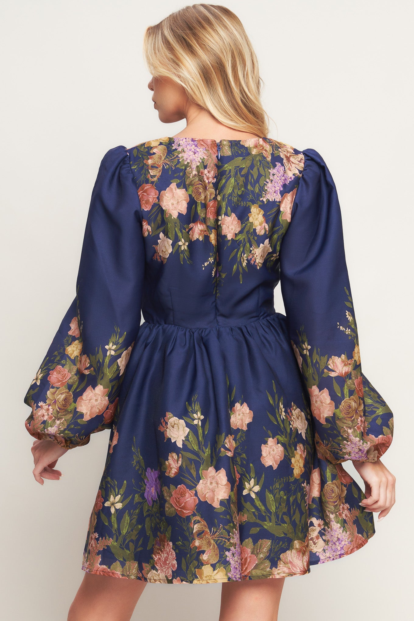 A printed woven mini dress featuring V neckline, long sleeve, full skirt and back zipper closure