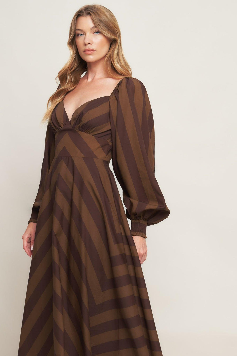 A printed woven midi dress featuring sweetheart neckline, long sleeve with smocked cuff, waist yoke, circle skirt and back zipper closure