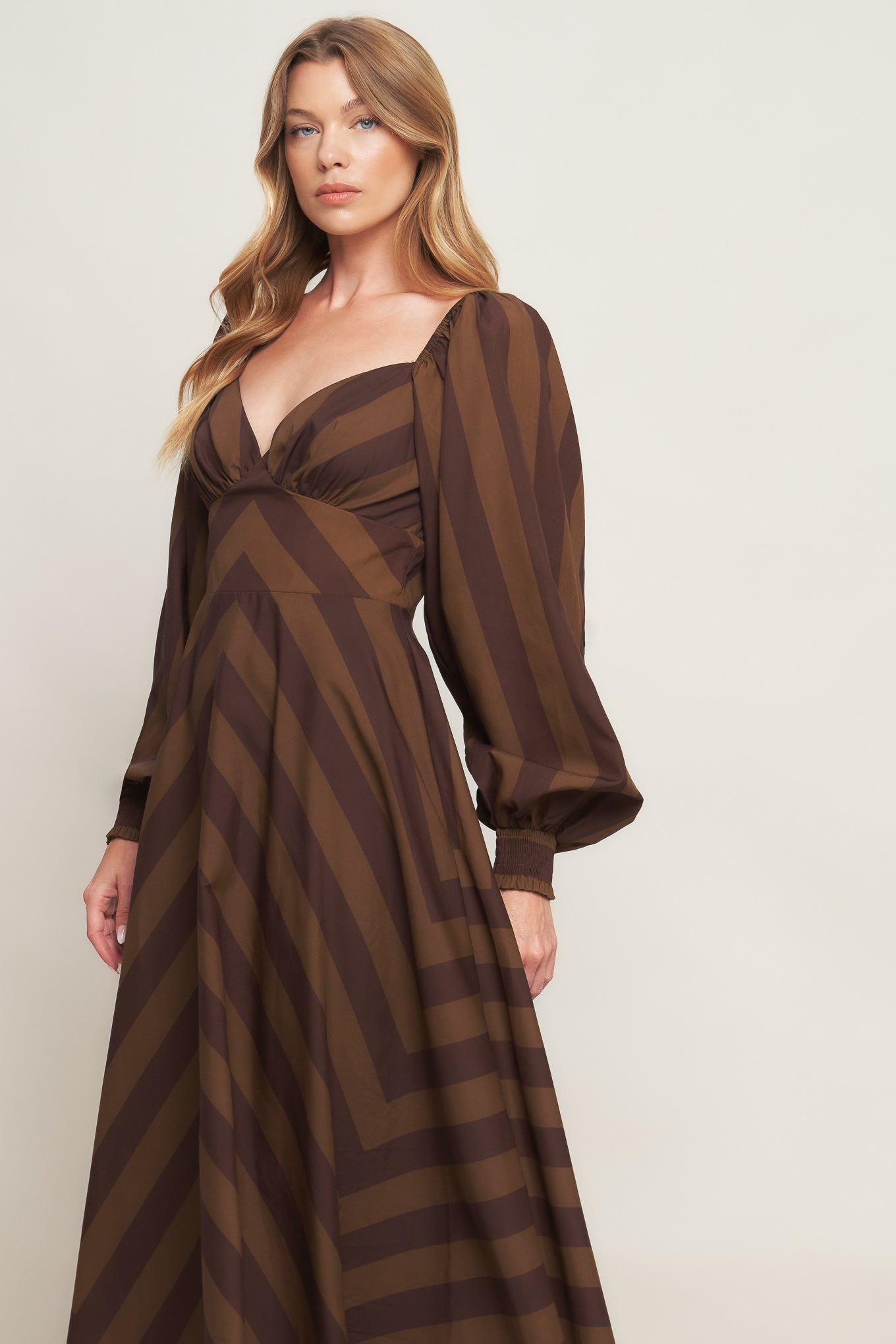 A printed woven midi dress featuring sweetheart neckline, long sleeve with smocked cuff, waist yoke, circle skirt and back zipper closure