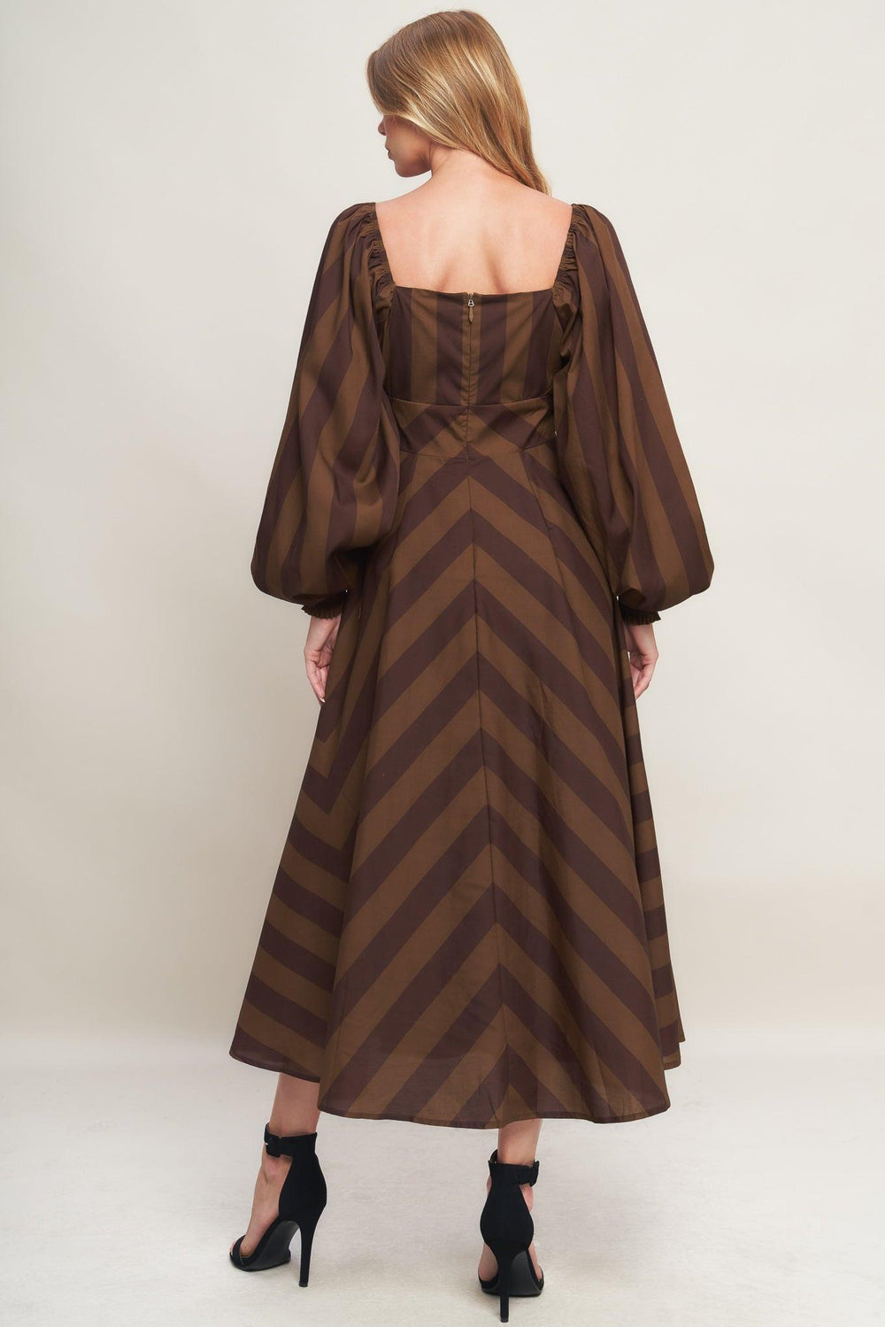 A printed woven midi dress featuring sweetheart neckline, long sleeve with smocked cuff, waist yoke, circle skirt and back zipper closure