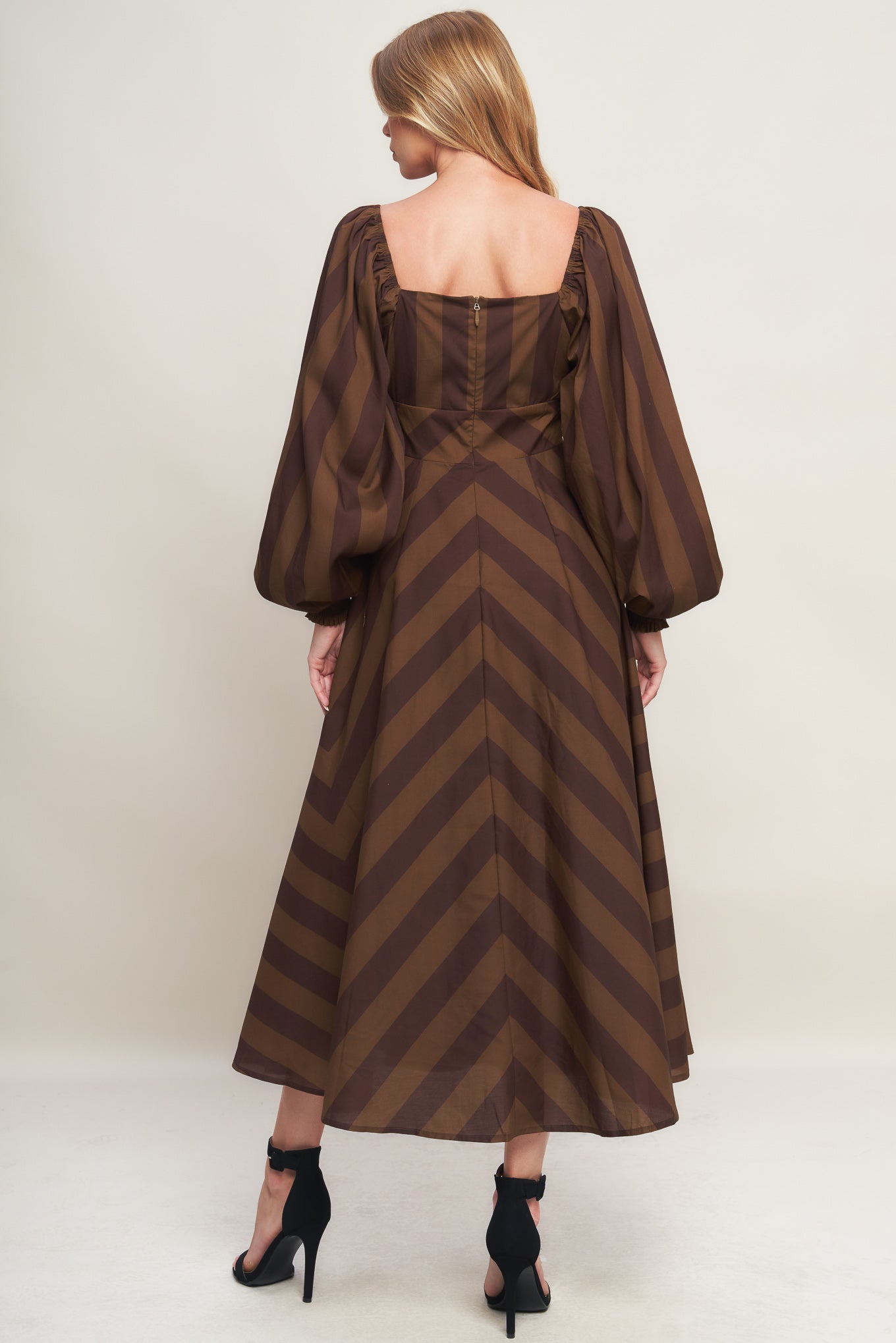 A printed woven midi dress featuring sweetheart neckline, long sleeve with smocked cuff, waist yoke, circle skirt and back zipper closure